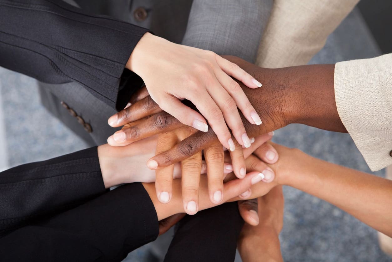 A group of people with their hands together.